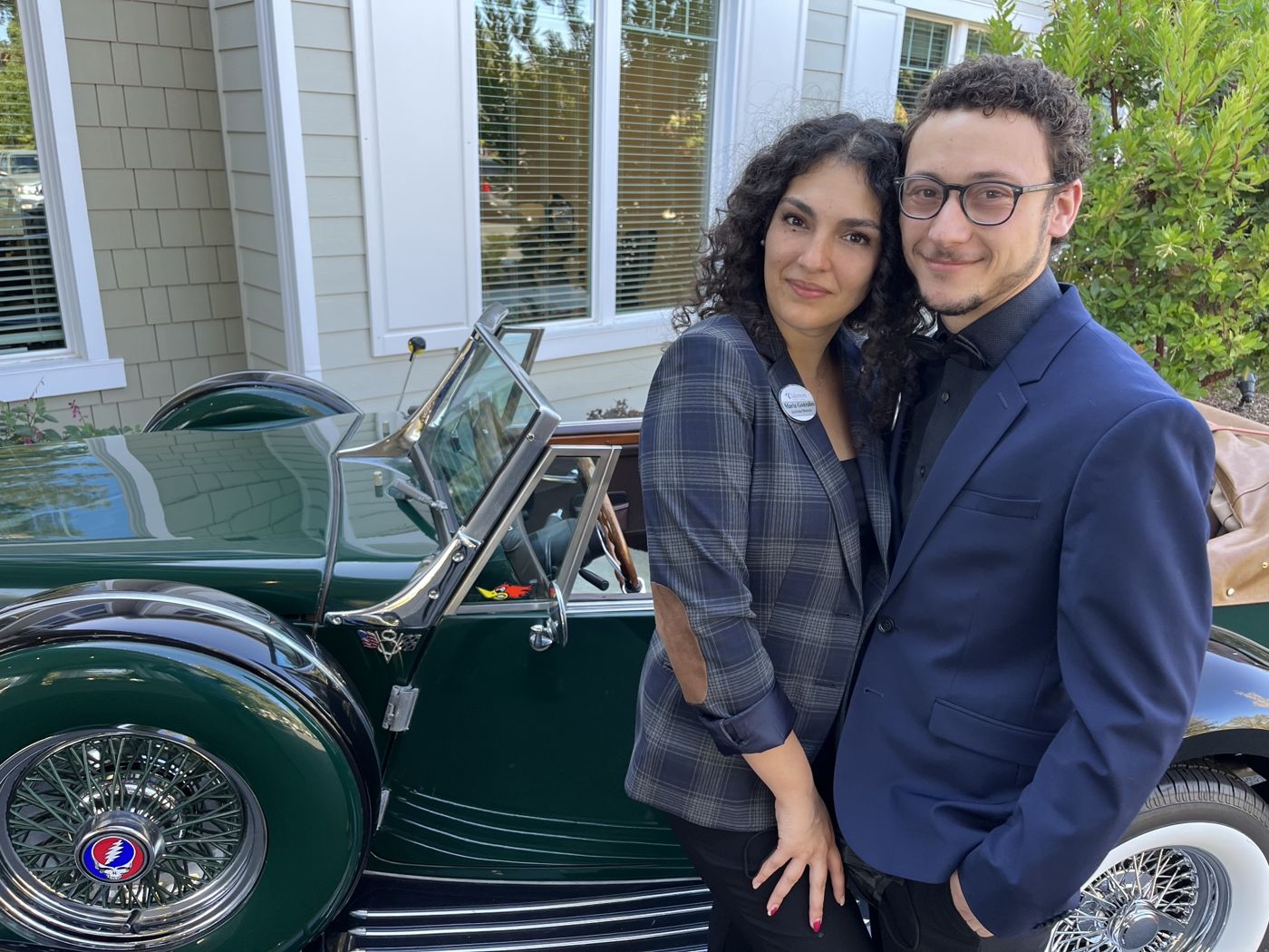 Tristan and Ileana dressed up beside a vintage green car