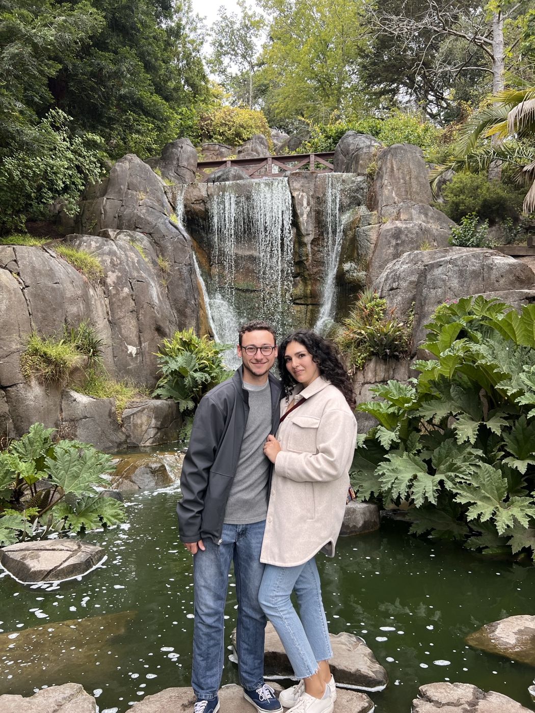 Tristan and Ileana in front of a waterfall